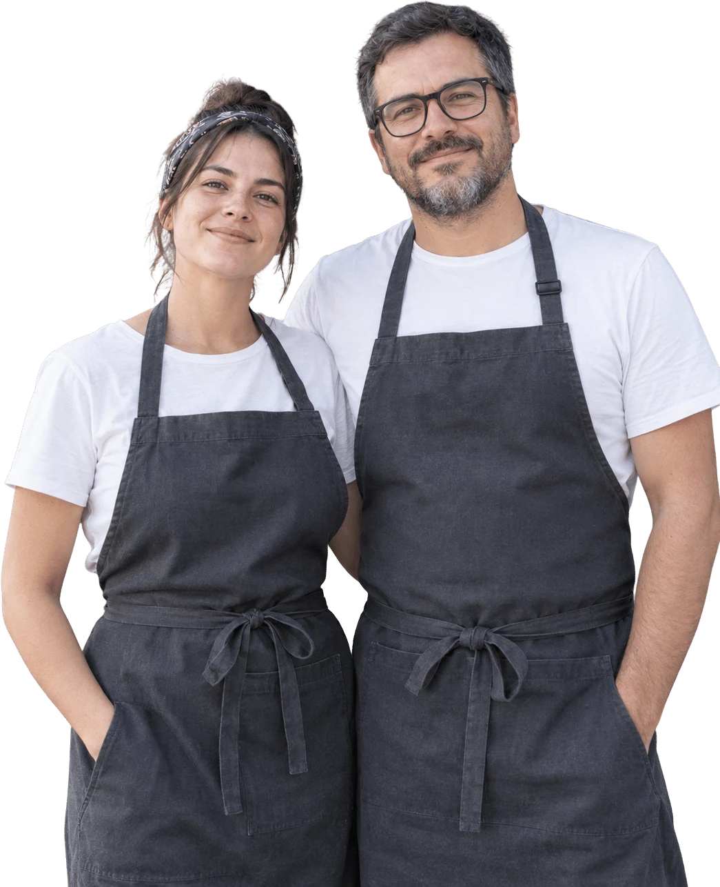 Una mujer y un hombre con delantal, socios de un food truck, sonriendo frente a la c&aacute;mara.